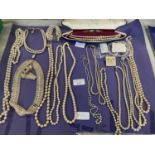 A large collection of assorted simulated pearl necklaces and other
