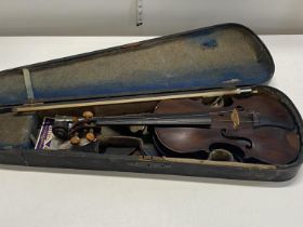 A antique violin in original wooden case. Paper label visible to the interior but not ledgible. Sold