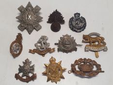 A selection of assorted military cap badges and other