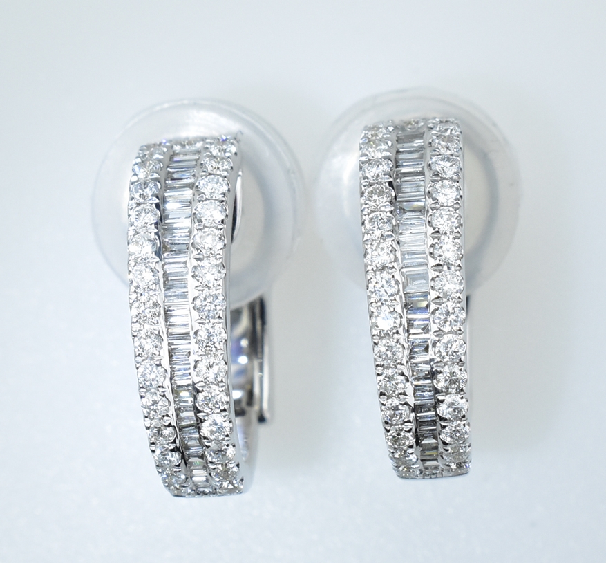 Paar Brillant-Halbcreolen. Mit 1,08 ct. Brillanten und Baguetten. 18 ct. WG. Klapp-Steckbrisur