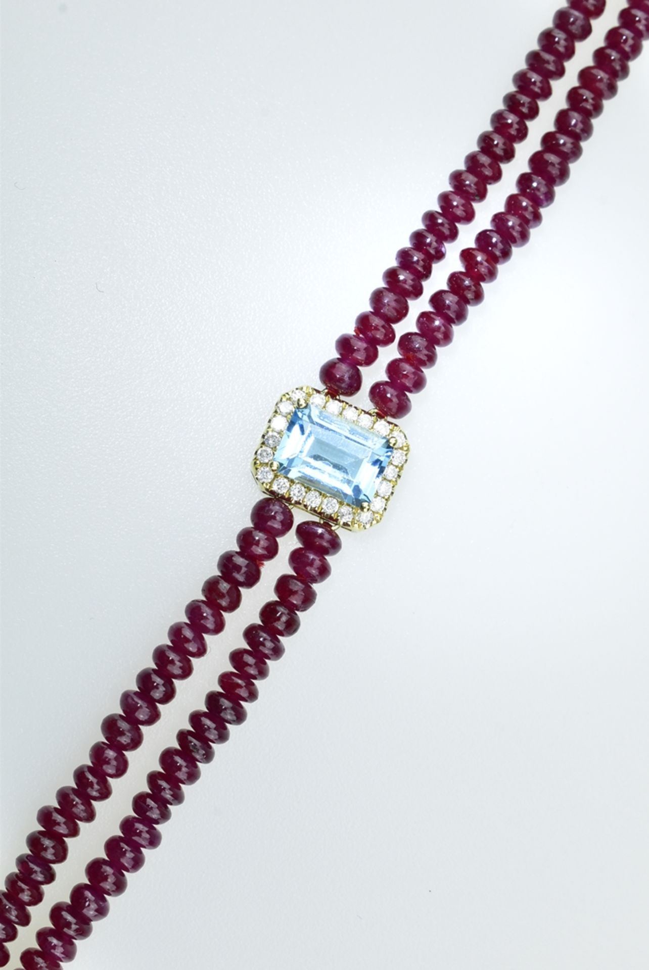 Reizendes Rubin-Topasarmband. Zwei Reihen mit Rubin-Rondellen 26,7 ct. Mittig gefasster Blautopas