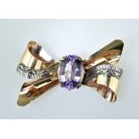 Hübsche Schleifenbrosche mit ovalem Amethyst. 14 ct. RG. L 3 cm. Um 1940