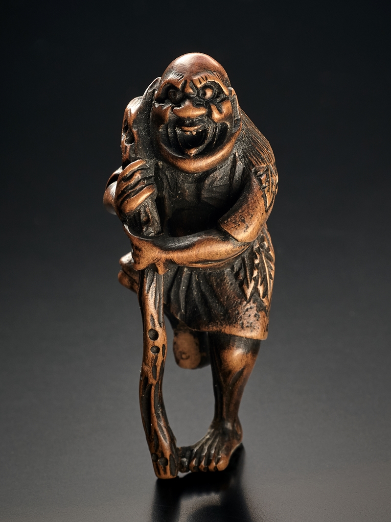 Netsuke. Tekkai Sennin im Blättergewand mit Stab. Ungedeutete Signatur. Kleine Fehlstelle am Fuß. B