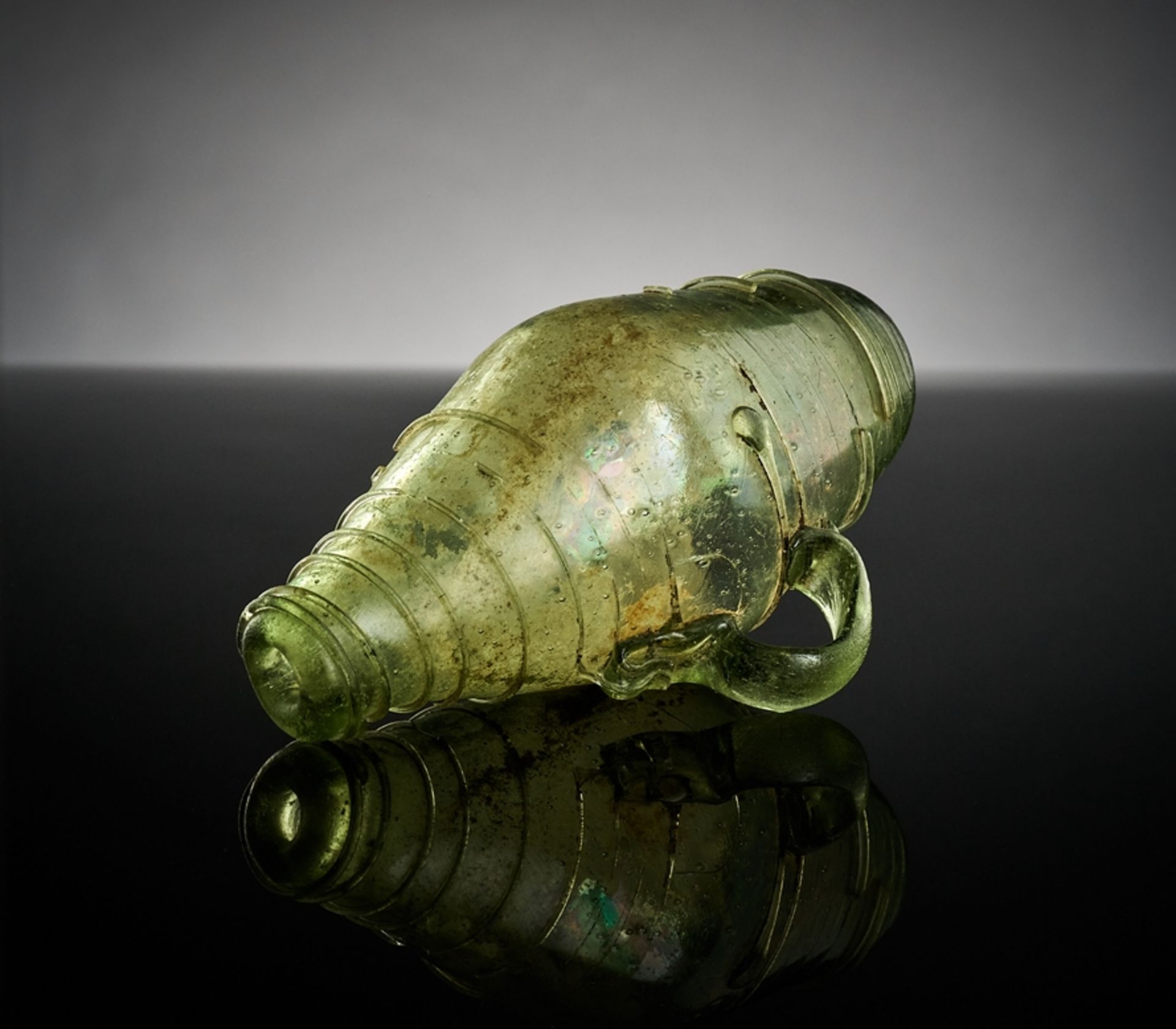 Kleines Henkelfäßchen. Grünes, lindgrünes Glas mit Spiralaufschmelzung. Wohl 17. Jh. H 12 cm
