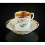 Zylindrische Tasse mit Untertasse. Polychrome Blüten und goldene Beschriftung: "Dein Bild (Rose) un