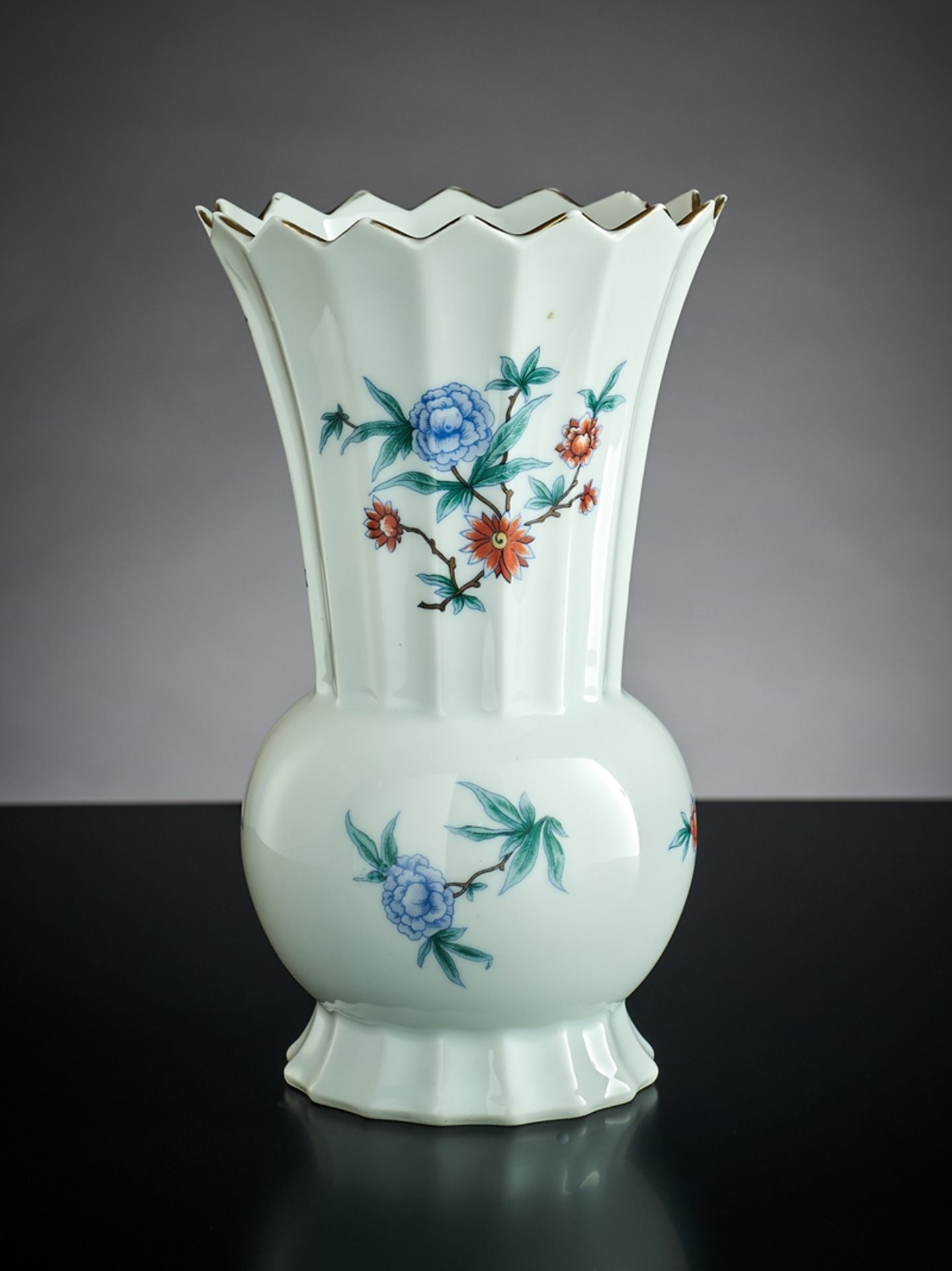 Vase. Kugeliger Korpus, facettierter Schaft mit gezacktem Rand (Stelle). Stilisierter Blumendekor. 