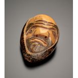 Netsuke. Ungewöhnliches Gesicht. Steinnuss, signiert Masatama. Rückseitig zwei kleine Himotoshi. H