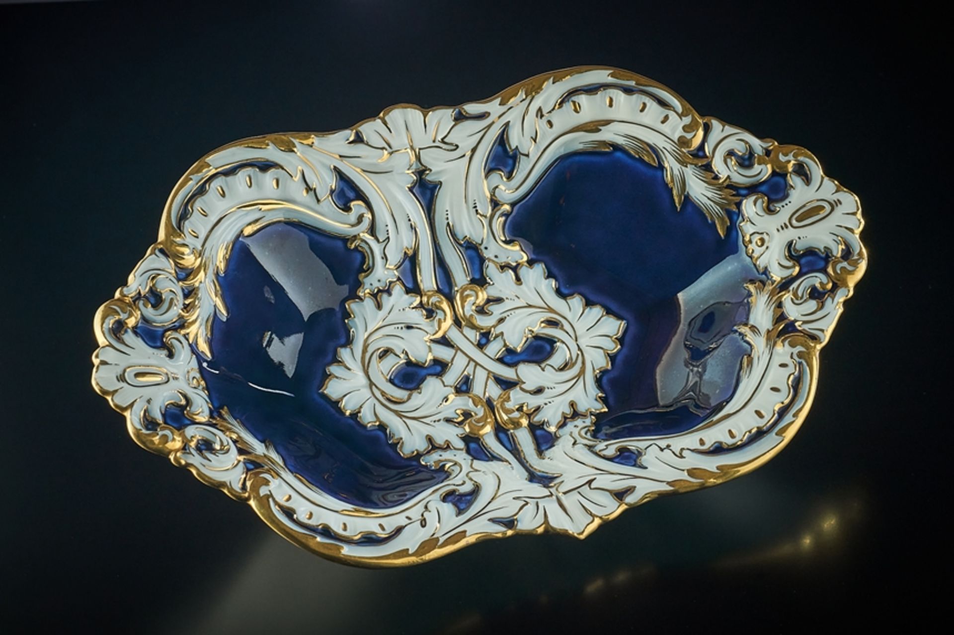 Ovale Schale mit kobaltblauem Fond. Reiche Goldstaffage, Blattwerk und Akanthus. Blaue Schwertermar