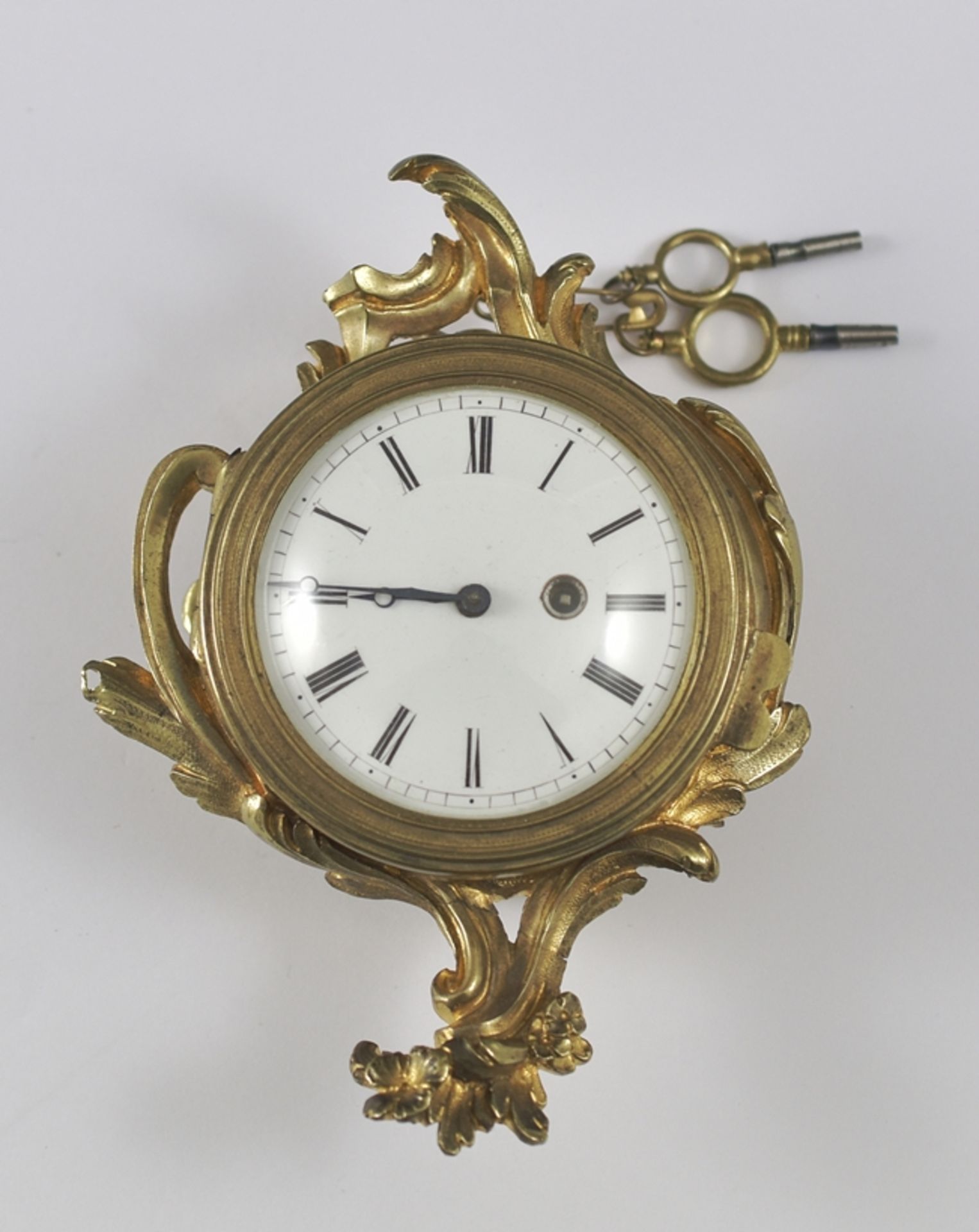 Kleine Wanduhr, sog. Pendulette.  Bronze doré-Gehäuse (unbed. St.). Verglaste, aufklappbare Lunette