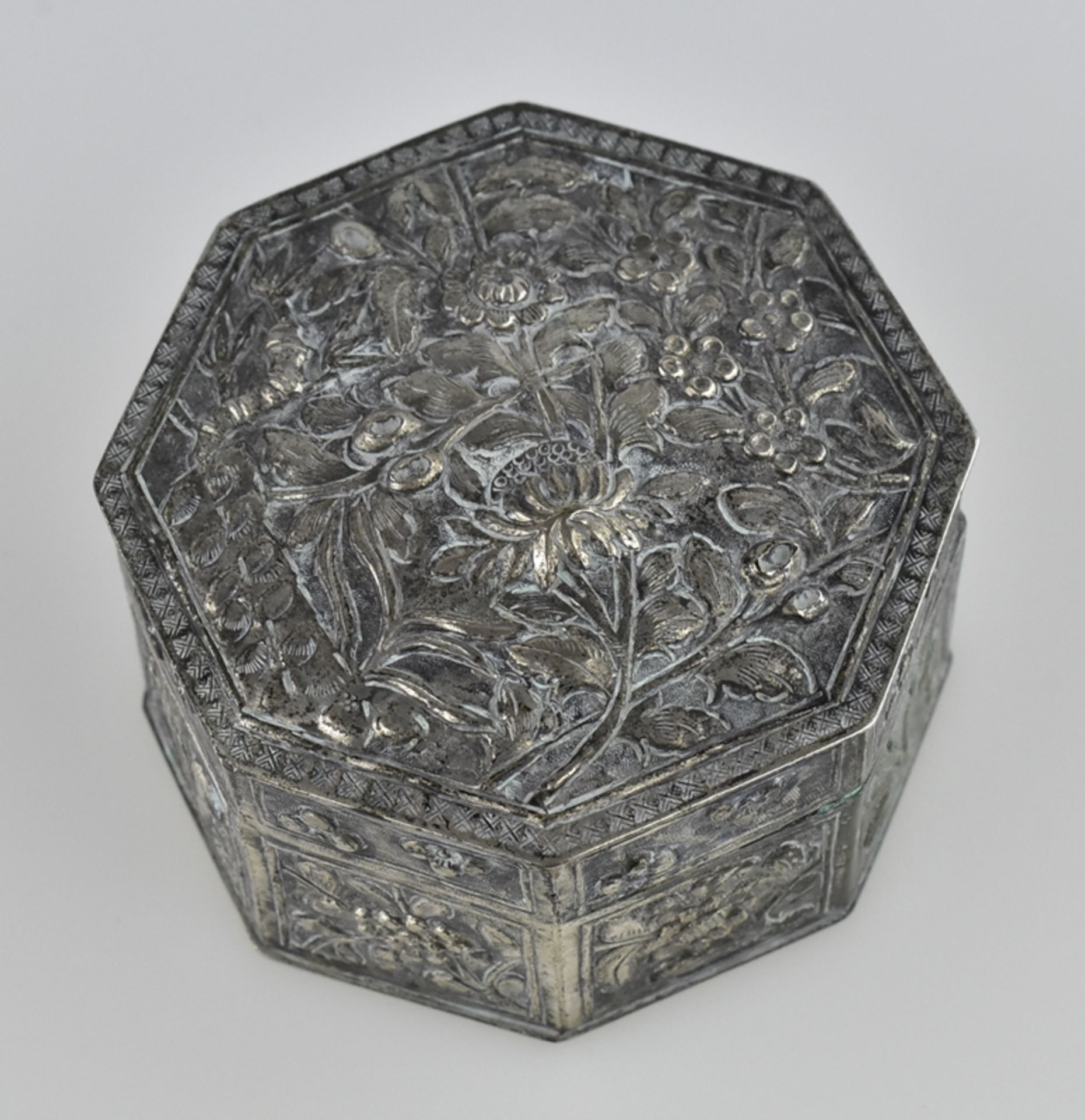 Oktagonale Silberdose. Blütenrelief. China, Anf. 20. Jh. Ø 6 cm.