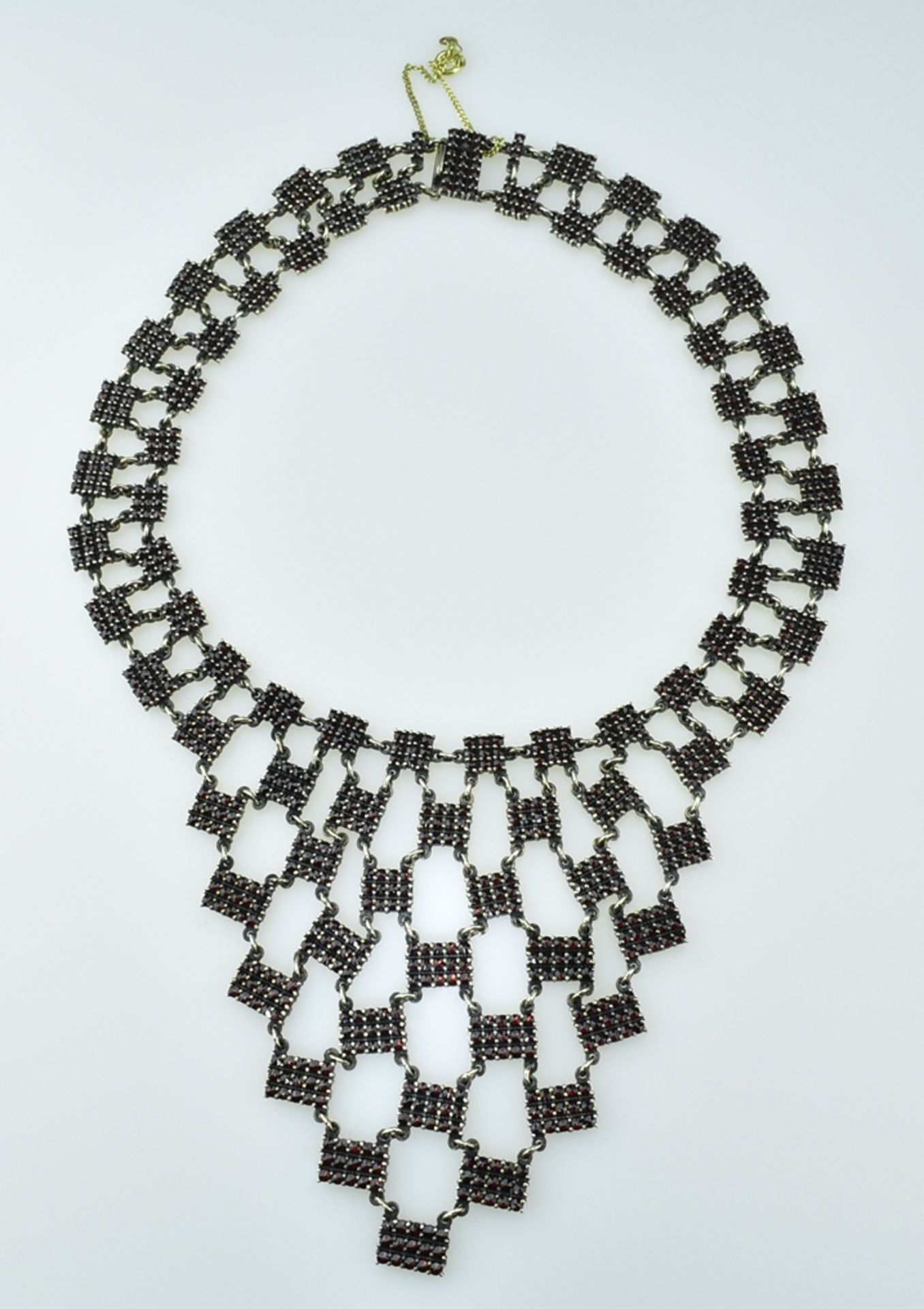 Vorstelliges Granatcollier.  Vermeilfassung. Mit Granaten ausgefasste Glieder. 1.H. 20. Jh. L 37 cm