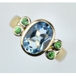 Topasring.  Ovaler, blauer Topas facettiert mit vier Tsavorithen zus. 4, 21 ct. 14 ct. RG