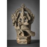 Vierarmiger Shiva auf Pfau reitend. Lalita Asana, vor Bogen mit Lotosbekrönung sitzend. Plinthenso