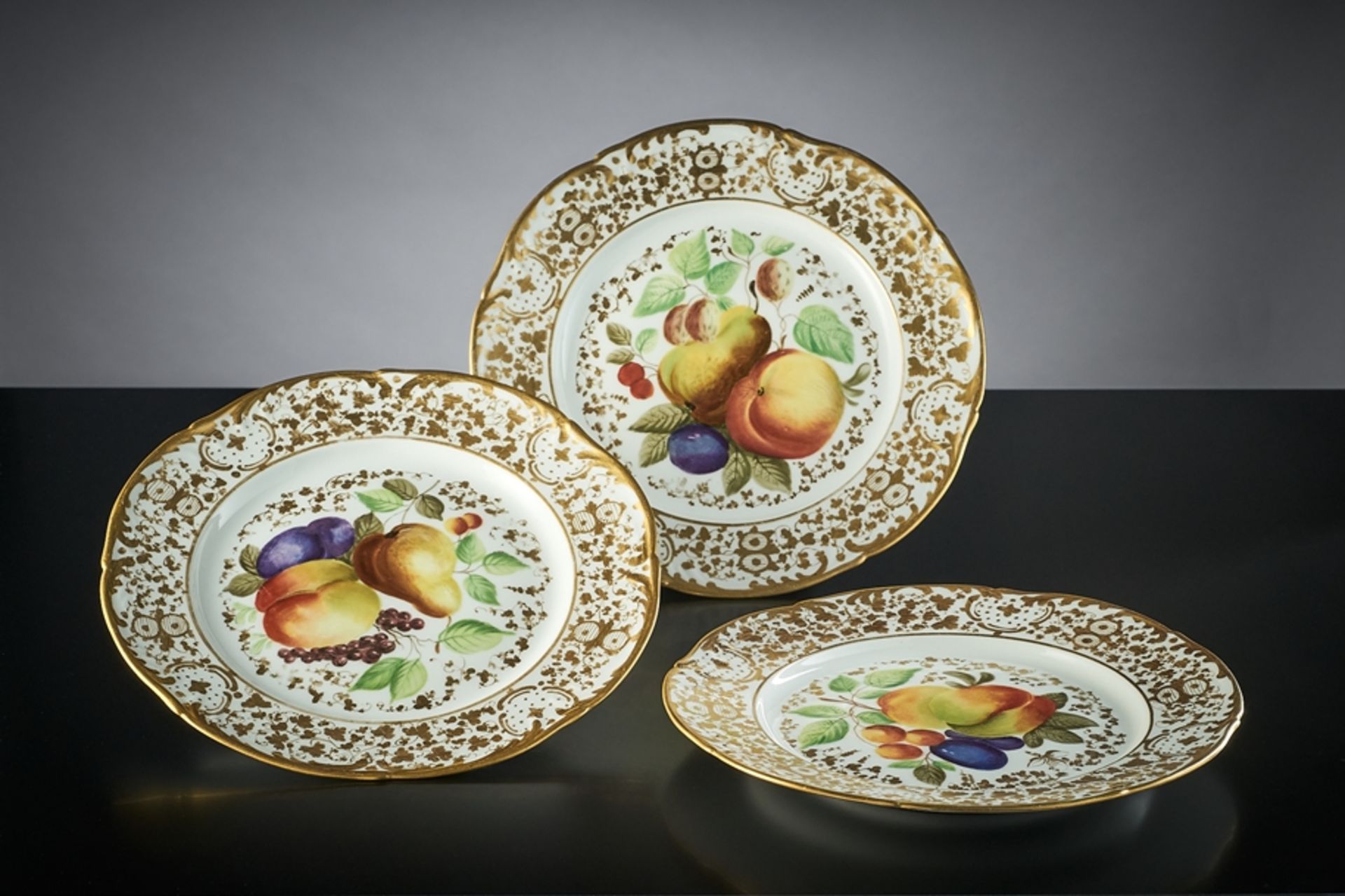 Drei dekorative Teller. Mit polychromer Früchtemalerei (Hausmalerei) und reicher Goldstaffage. Zep