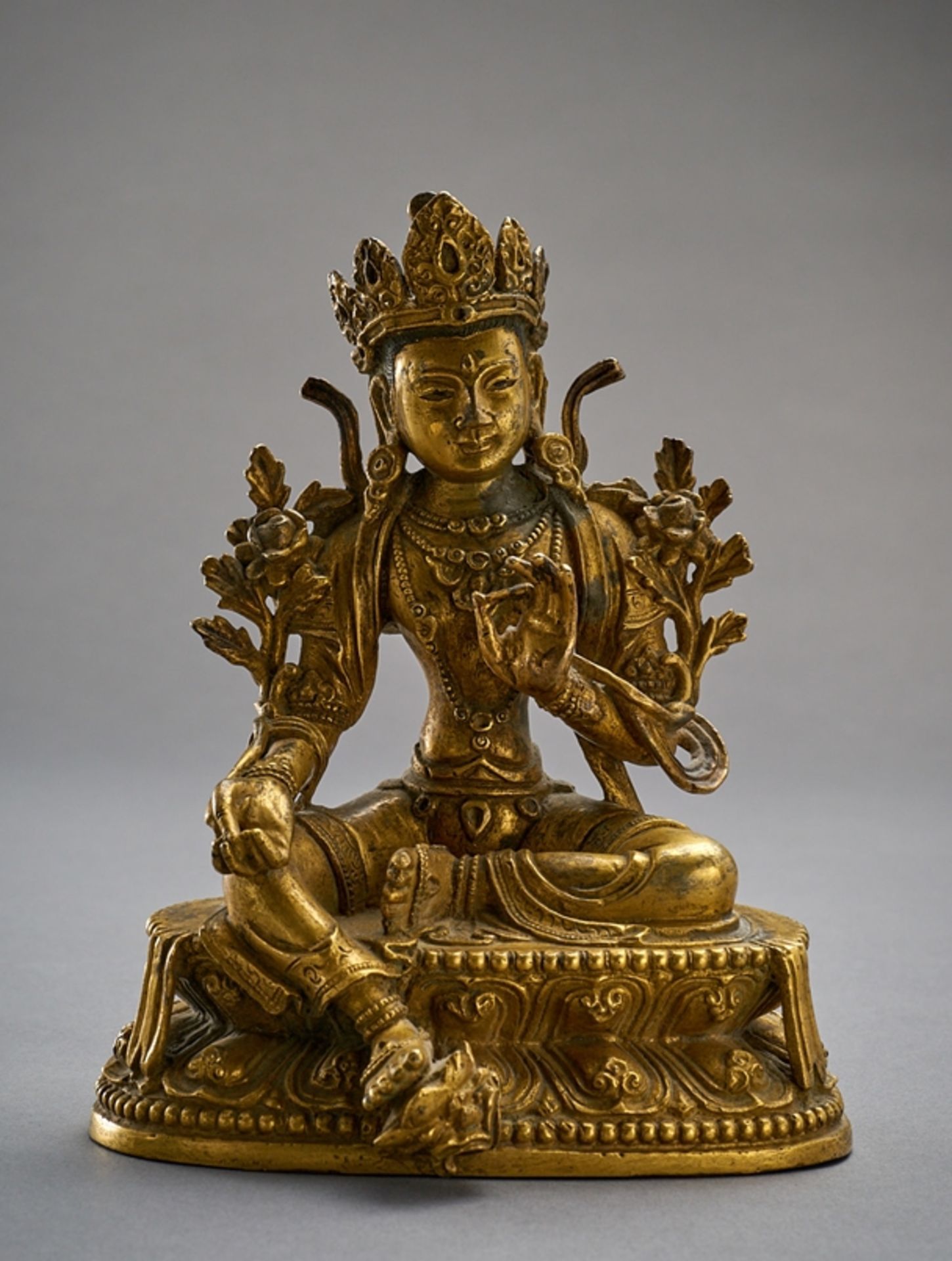 Bodhisattva Avalokitesvara. In Lalita asana. Vitarka mudra. Reich geschmückt. Seitlich Lotosranken.
