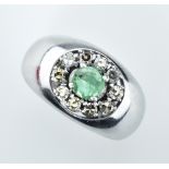 Smaragd-Diamantring. Mittig runder, facettierter Smaragd mit ca. 0,40 ct. Diamanten karmosiert. Gl