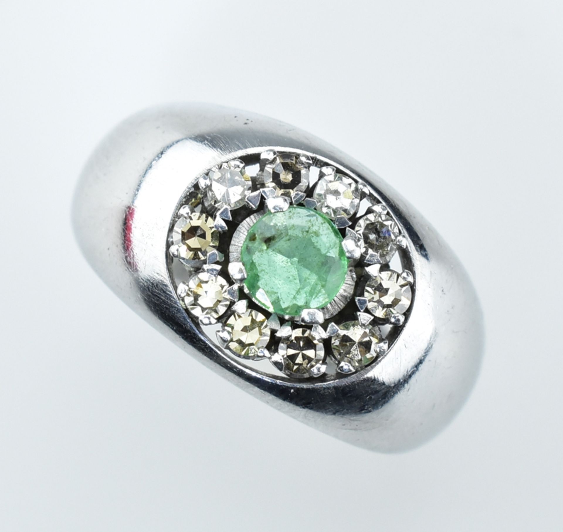 Smaragd-Diamantring. Mittig runder, facettierter Smaragd mit ca. 0,40 ct. Diamanten karmosiert. Gl