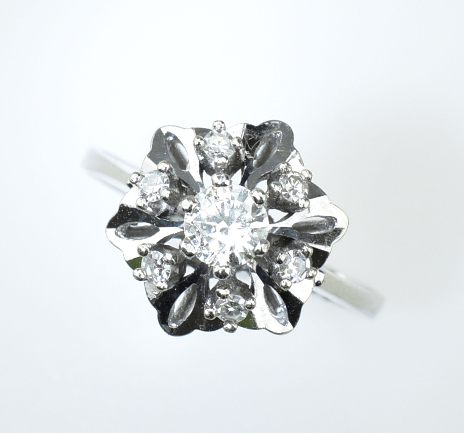 Feiner Brillantring. Blütenförmig gefasst. Mittelstein ca. 0,28 ct. entouriert mit sechs Diamanten