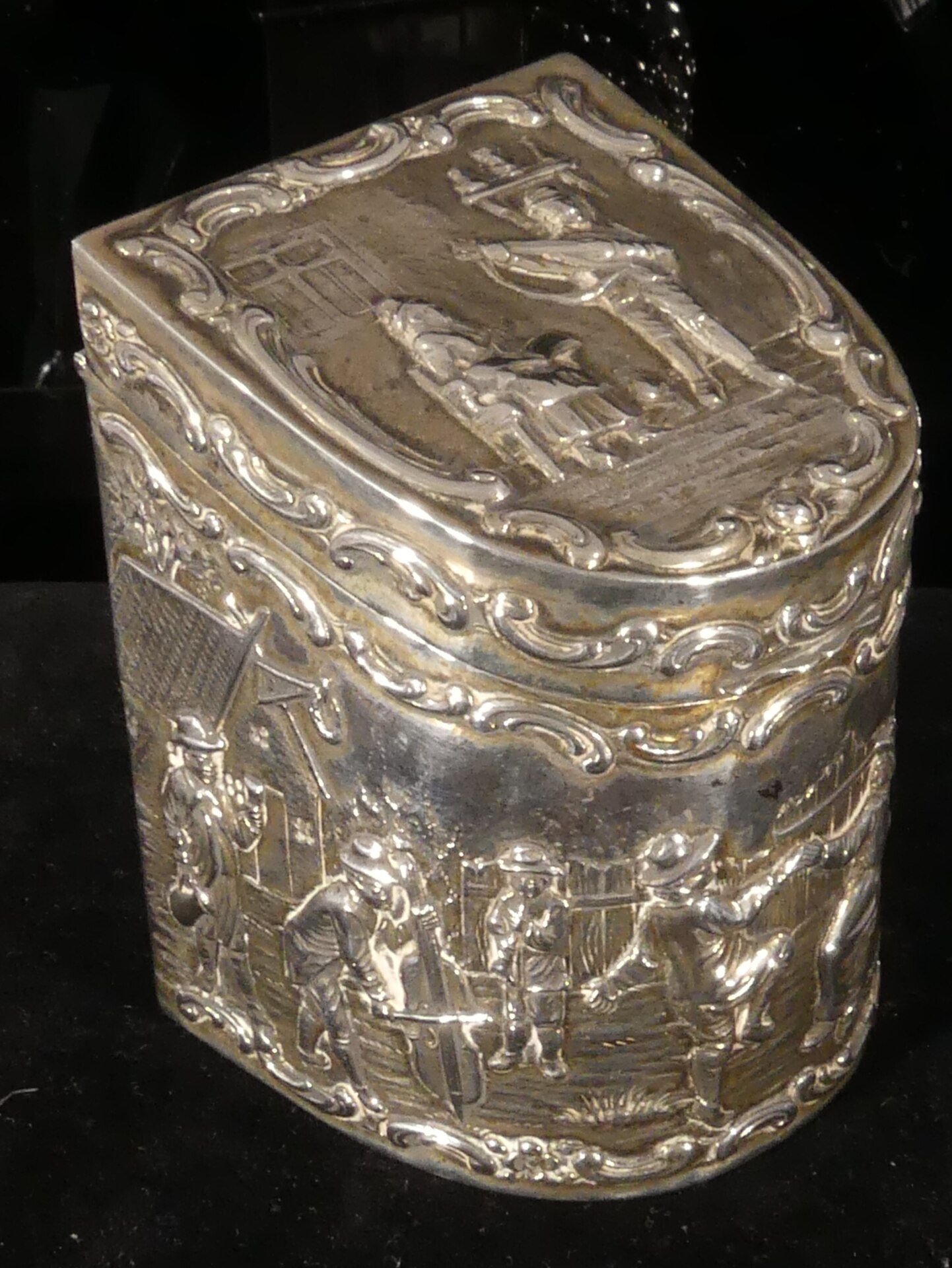 Teedose in nicht alltäglicher Formgebung, Deckel und rundum mit reliefierten Dekoren. 800er Silber,