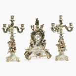 A three-piece mantlepiece set - magnificent pendulum clock on a pedestal and a pair of four-light gi