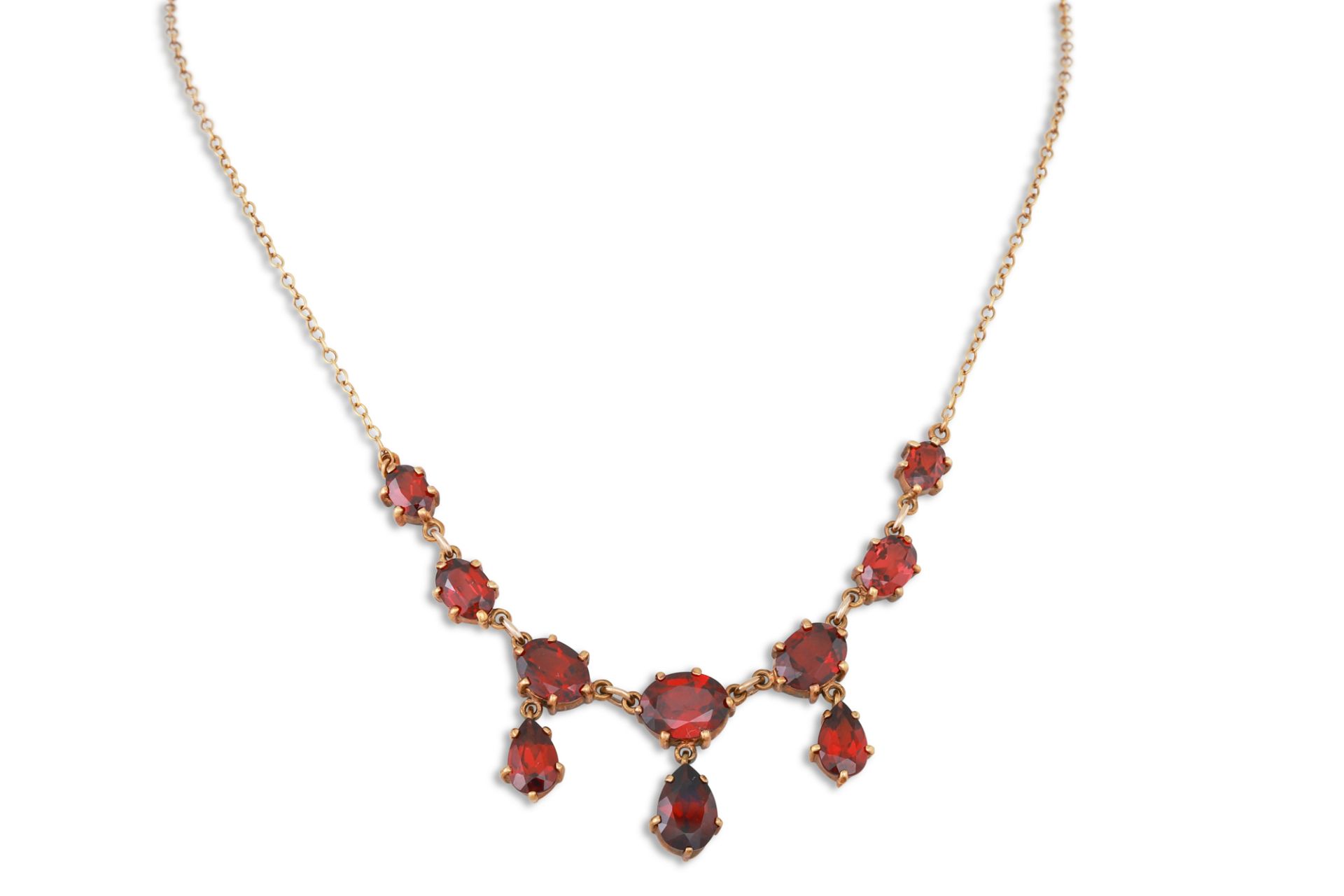 AN ANTIQUE GARNET NECKLACE, the pear, and oval garnets suspended from a yellow gold chain, mounted