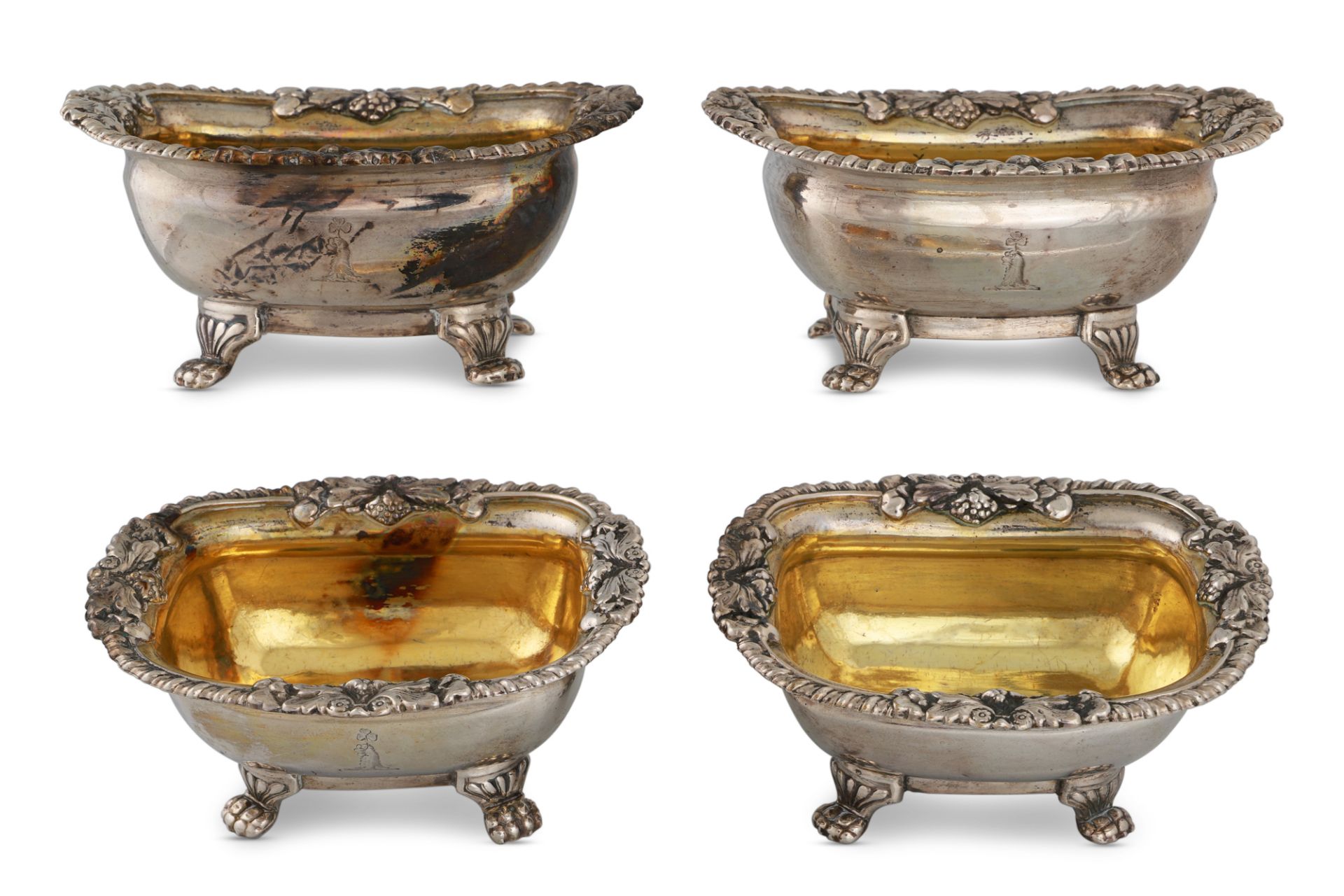 A SET OF FOUR GEORGE III IRISH SILVER SALTS, of generous form, gilded interior, raised over four