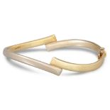 A TWO COLOUR GOLD HINGED BANGLE, in 9ct two gold