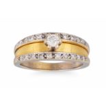 A DIAMOND SOLITAIRE RING, the round brilliant cut diamond to diamond border, in two colour gold.