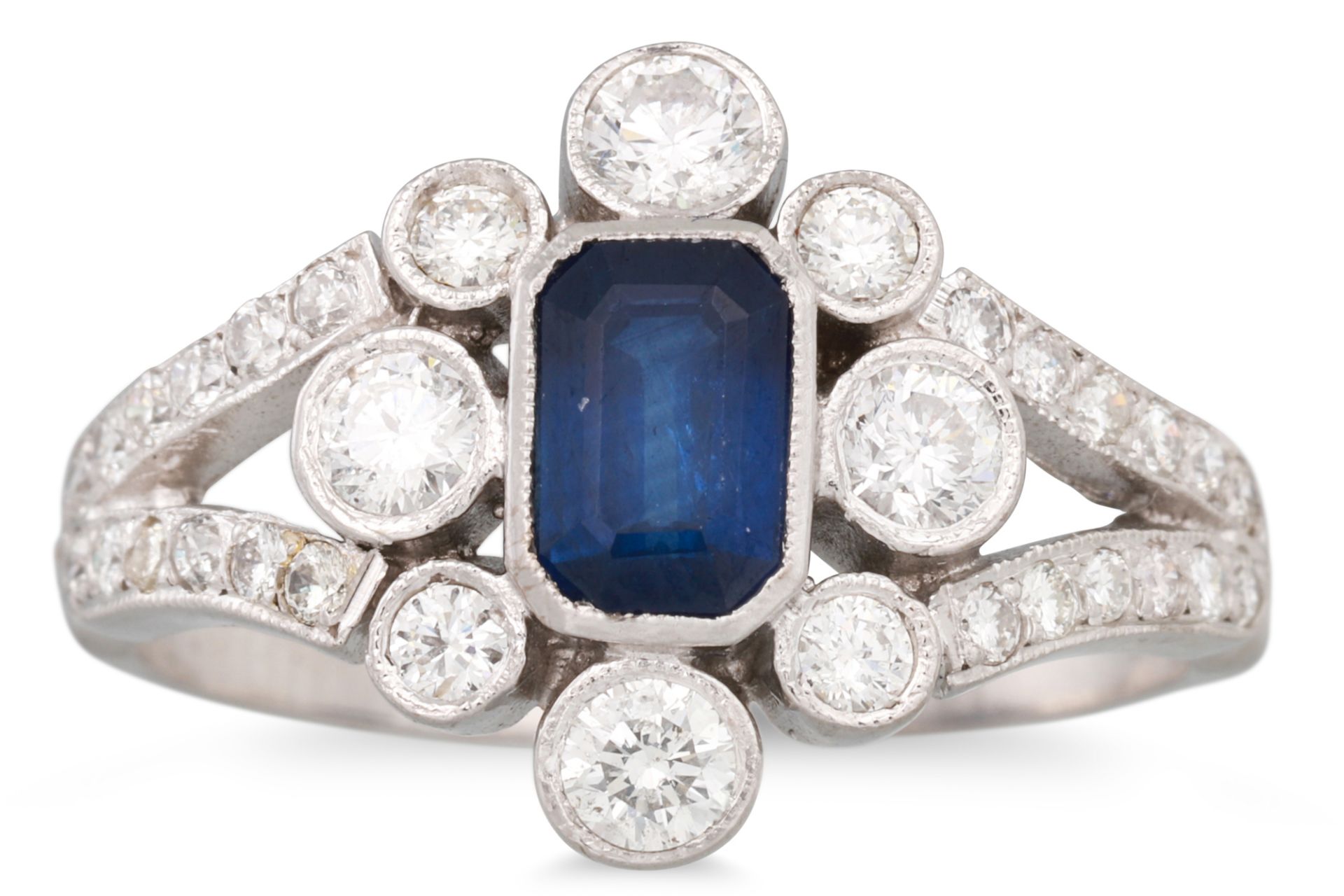 A DIAMOND AND SAPPHIRE CLUSTER RING, the octagonal sapphire to a diamond surround & shoulders,