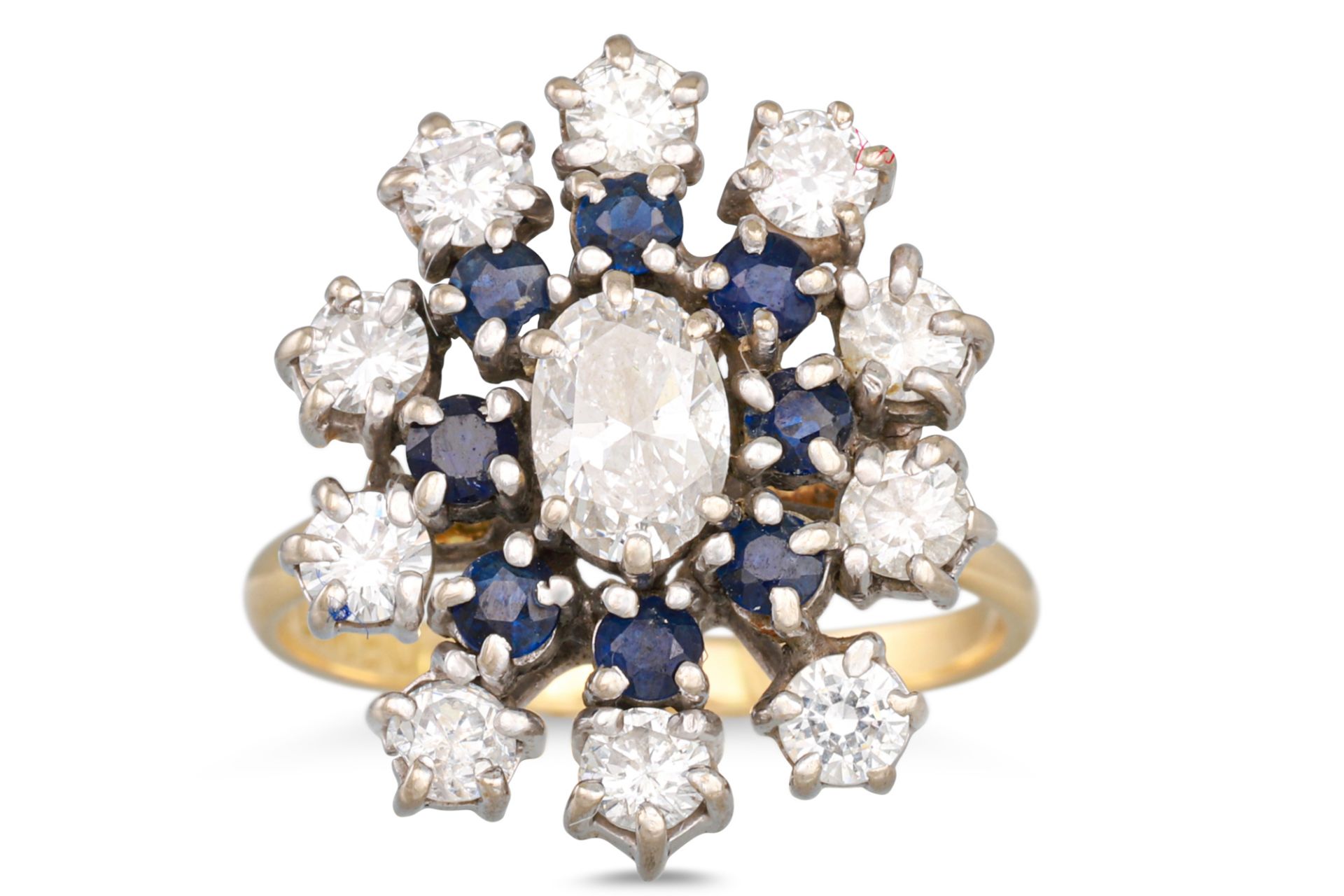 A SAPPHIRE AND DIAMOND CLUSTER RING, the central oval cut diamond to sapphire surround to outer