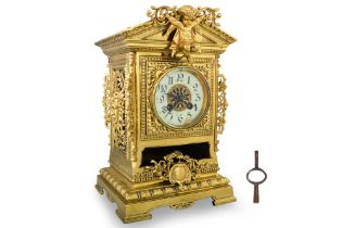 A LATE 19TH CENTURY ORNATE BRASS TABLE MANTLE CLOCK, of architectural form with applied putti
