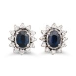 A PAIR OF DIAMOND AND SAPPHIRE CLUSTER EARRINGS, an oval sapphire to diamond surround, mounted in
