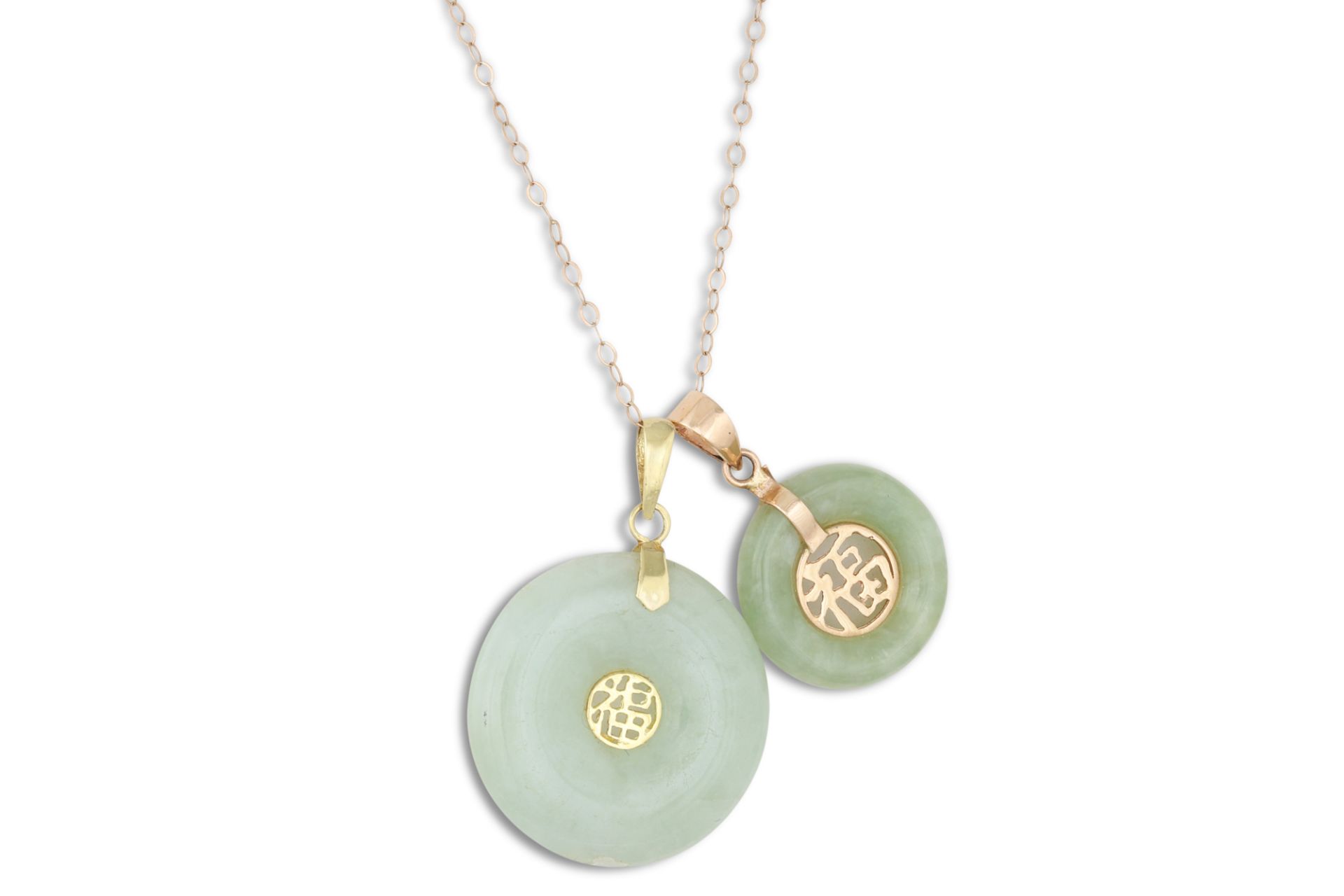 TWO JADE PENDANTS, of circular form, oriental design in 14ct gold, on a 9ct gold chain