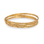 A GROUP OF THREE 20CT GOLD BANGLES, ornate decoration, 30 g.