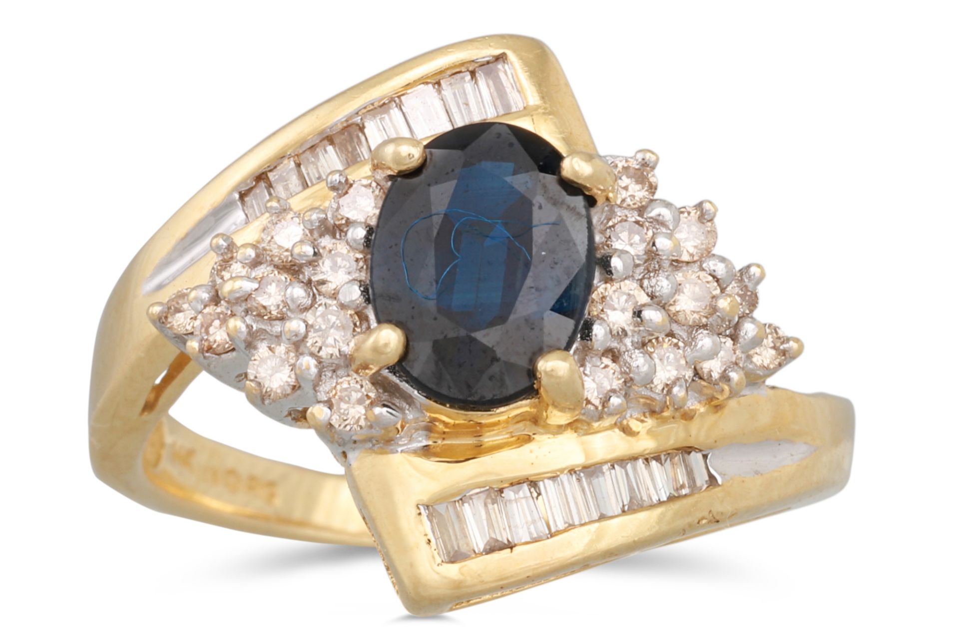 A DIAMOND AND SAPPHIRE CLUSTER RING, the oval sapphire to diamond surround and shoulders, mounted in