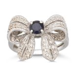 A DIAMOND AND GEM SET RING, modelled as a bow, mounted in white gold. Size: N - O