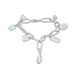 AN AQUAMARINE BRACELET, comprising of 18ct white gold links, suspending aquamarine charms.