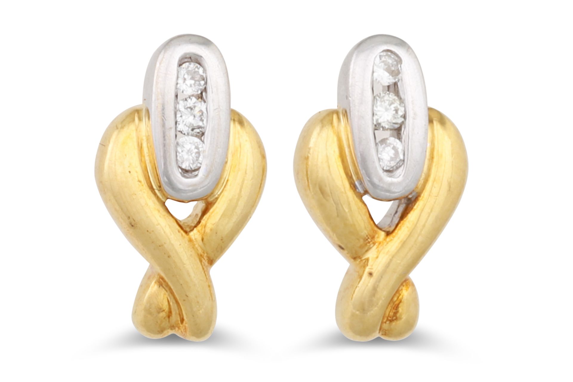 A PAIR OF DIAMOND SET EARRINGS, mounted in 18ct white and yellow gold, of cross over design, mounted