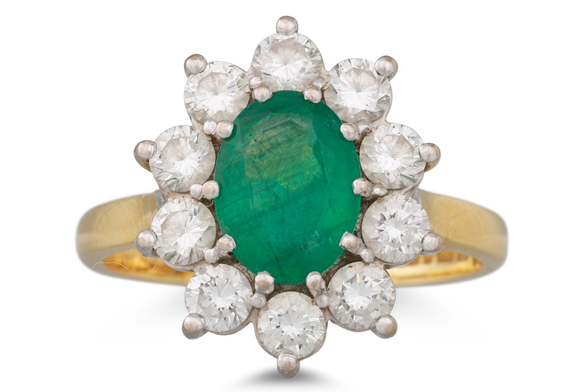 AN EMERALD AND DIAMOND CLUSTER RING, the oval emerald to a brilliant cut diamond surround, mounted