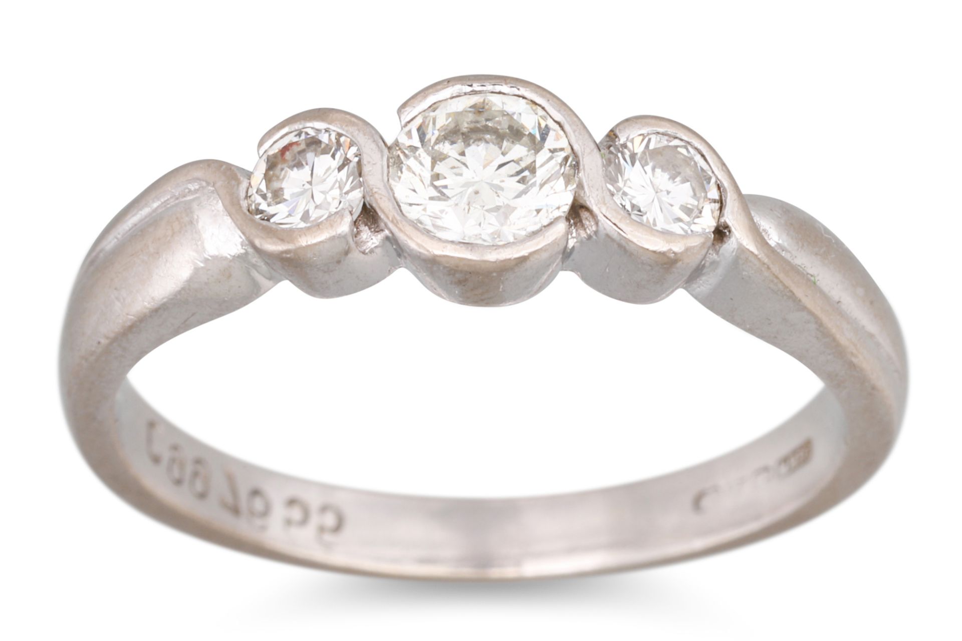 A THREE STONE DIAMOND RING, mounted in platinum. Size: L