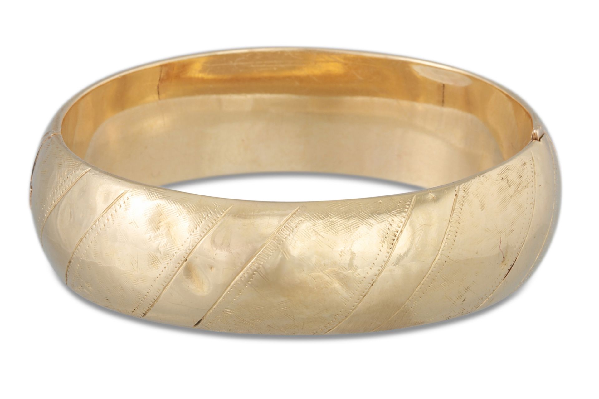 A VINTAGE GOLD HINGED HOLLOW BANGLE, with engraved decoration, 24 g. *** testing as 55%