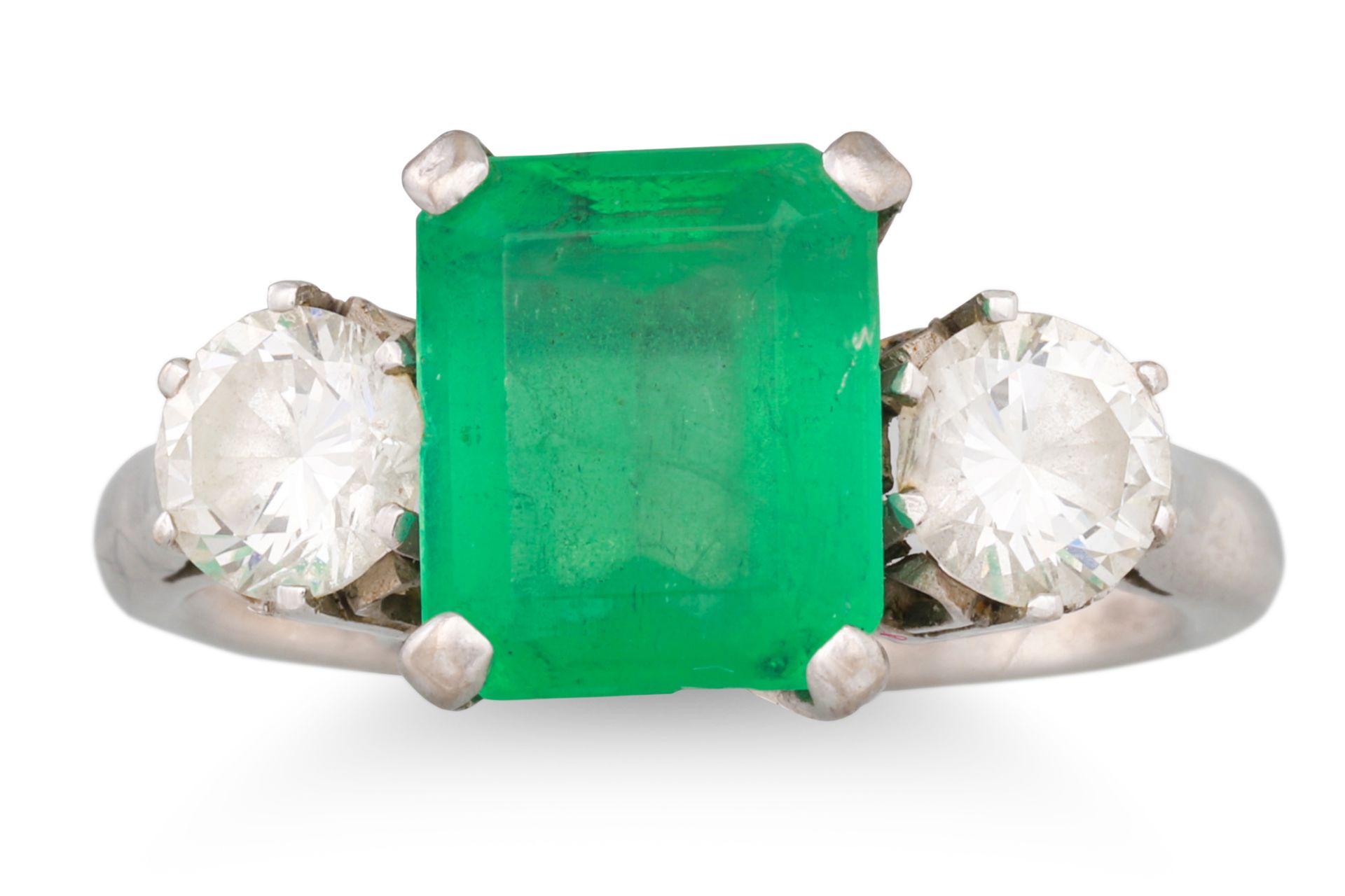 AN EMERALD AND DIAMOND THREE STONE RING, the rectangular emerald to brilliant cut diamonds,