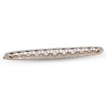 AN EDWARDIAN DIAMOND BAR BROOCH, of openwork form, set with old cut diamonds, mounted in white and