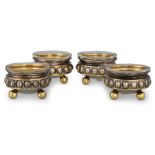 A SET OF FOUR GERMAN (.800 silver) gilt circular salt cellars, with clear glass liners, raised