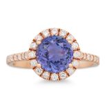 A TANZANITE AND DIAMOND CLUSTER RING, the circular stones to diamond surround and shoulders, mounted