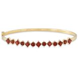 A GARNET AND GOLD HINGED BANGLE, the round and square garnet mounted in 18ct gold, 10.3 g.