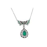 AN EDWARDIAN EMERALD, DIAMOND AND ONYX DROP PENDANT, comprising a bow shaped plaque suspending a