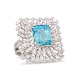 A TOPAZ AND DIAMOND RING, the trap cut topaz to a light pink diamond surround, mounted in white