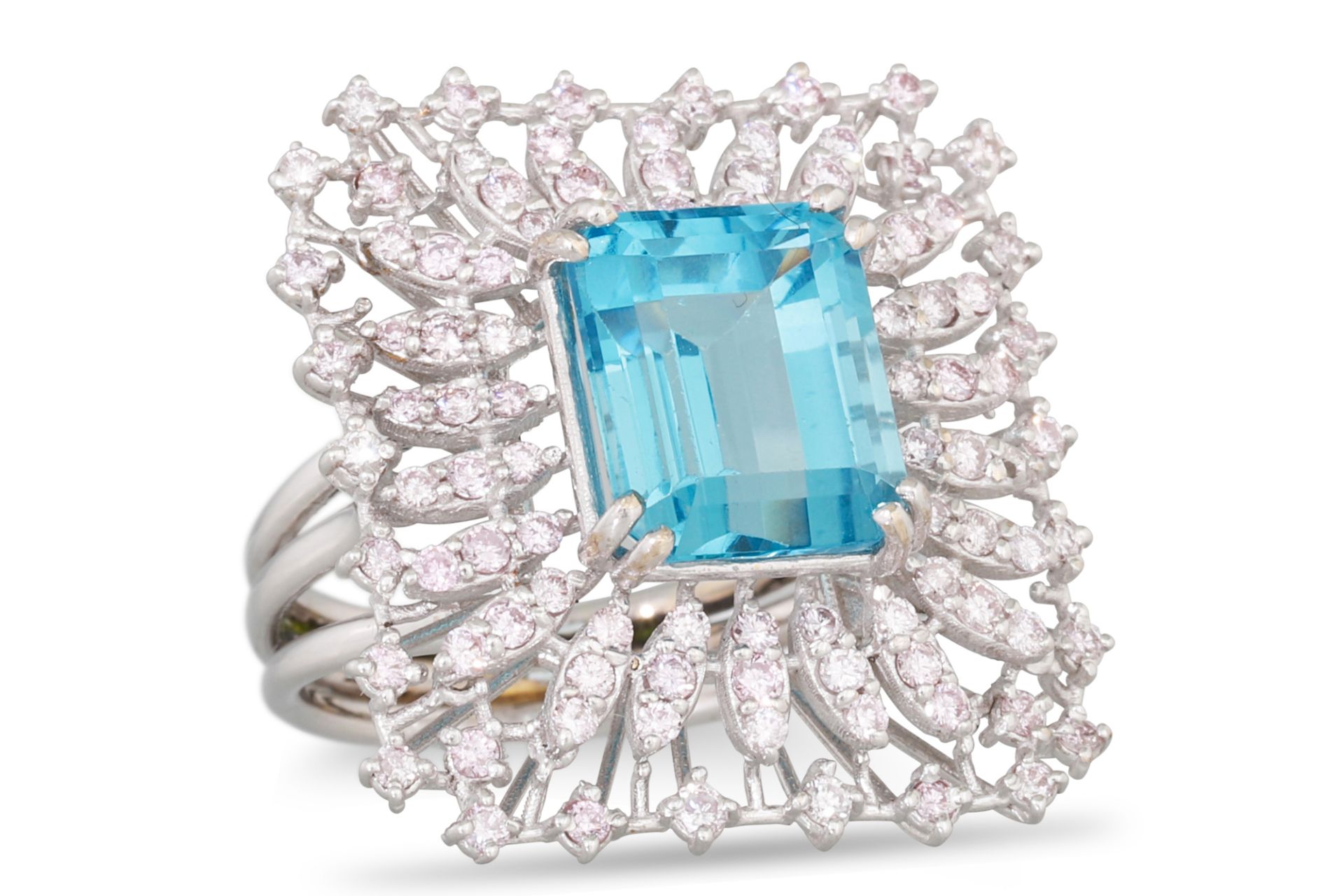 A TOPAZ AND DIAMOND RING, the trap cut topaz to a light pink diamond surround, mounted in white