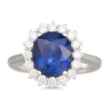 A SAPPHIRE AND DIAMOND RING, the oval sapphire to a brilliant cut diamond surround, mounted in